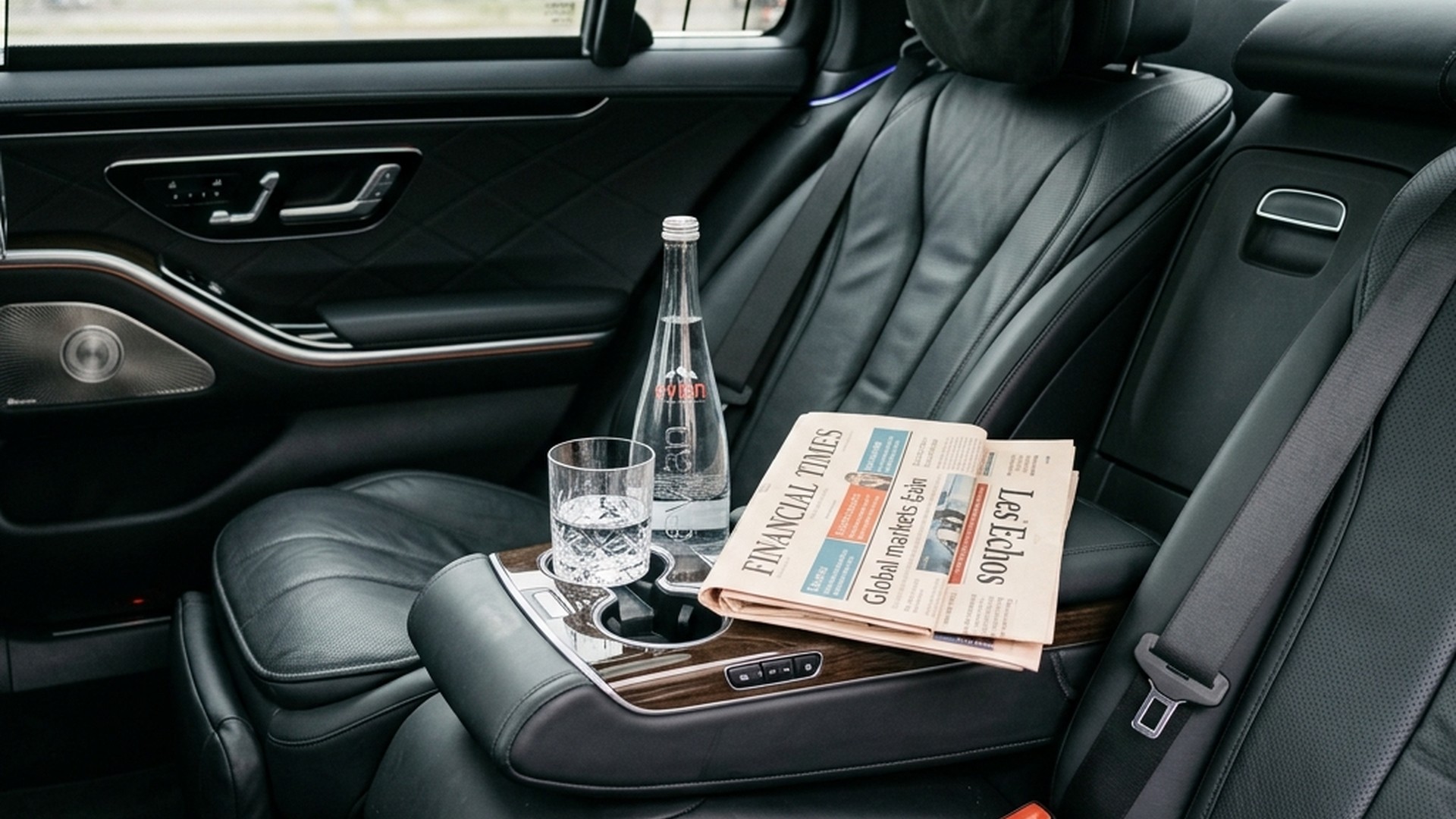 Suited executive chauffeur standing by luxury Mercedes sedan in central Paris